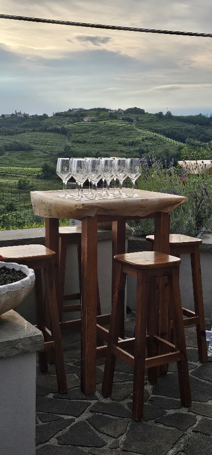 Tavolo con calici affacciato sui vigneti